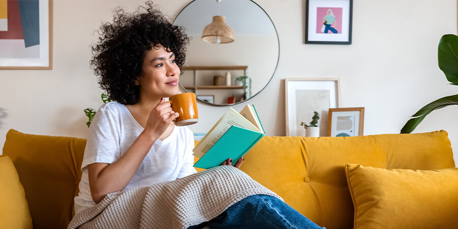 Woman enjoying a cool morning with a book indoors